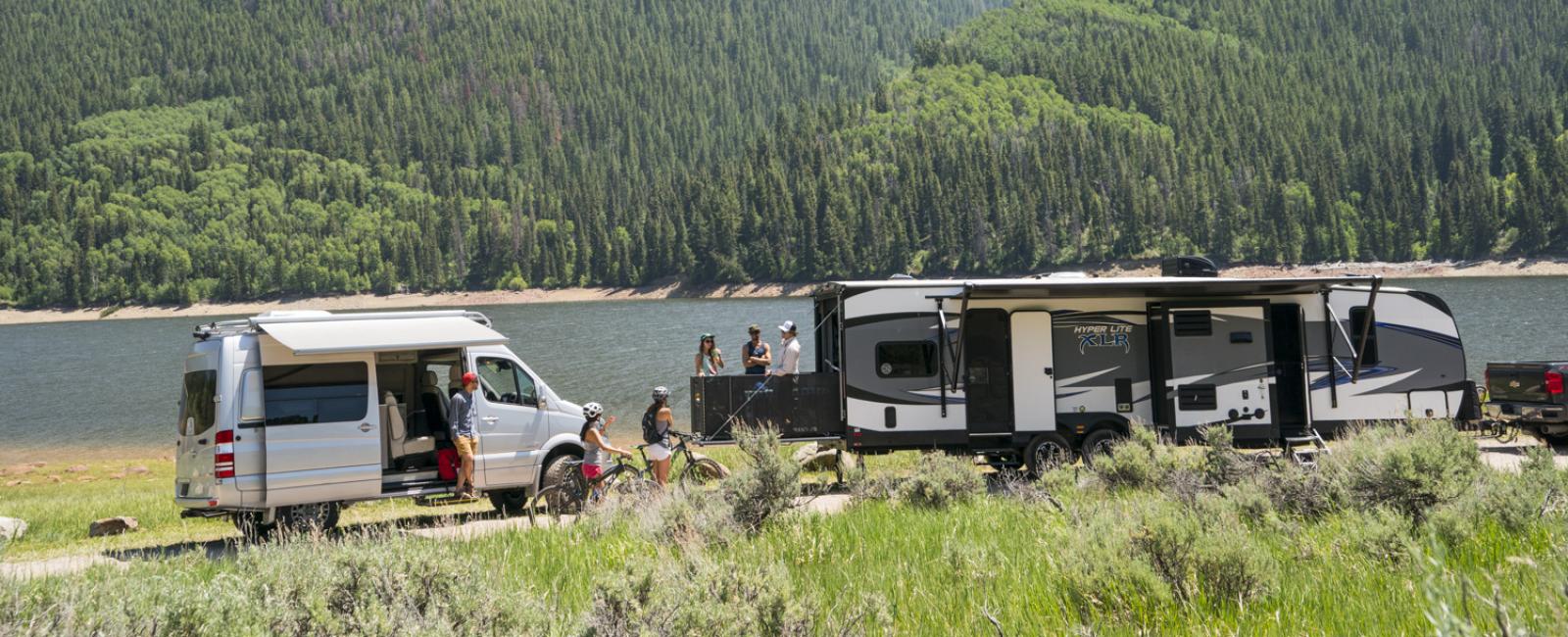 RVs parked next to water and mountains